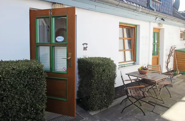 Eingangsbereich über den Hof mit Gartenstühlen