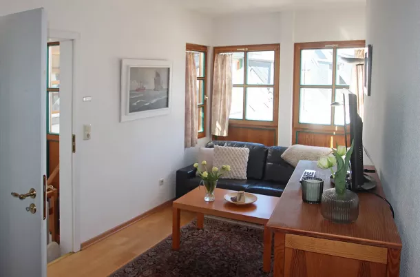 Wohnzimmer mit Couch, Kommode und TV
