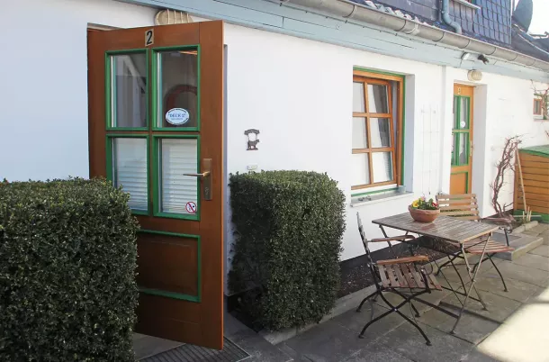 Eingangsbereich über den Hof mit Gartenstühlen