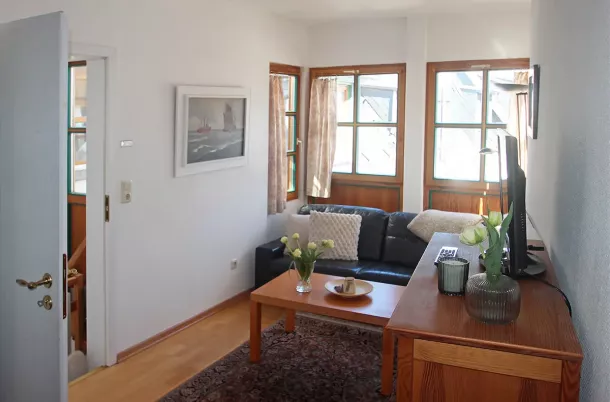 Wohnzimmer mit Couch, Kommode und TV